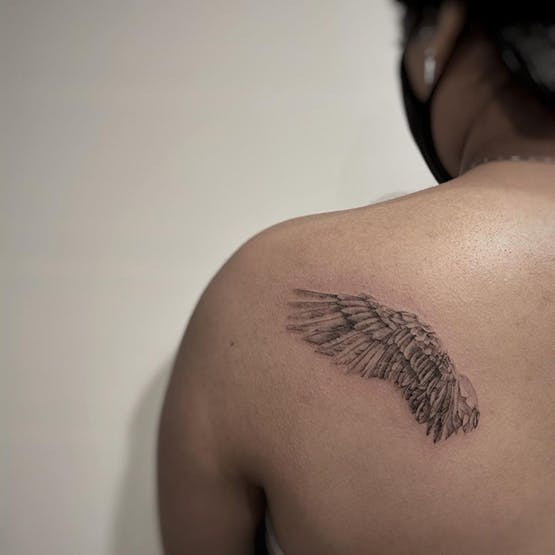 Angel wings miscarriage tattoo on upper back.