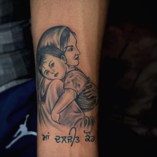 A mom portrait tattoo with detailed shading on a man's chest, sentimental and loving