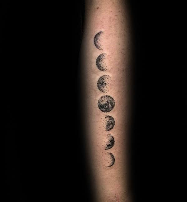 Moon phases arm tattoo depicting a series of crescent to full moon phases in a linear design