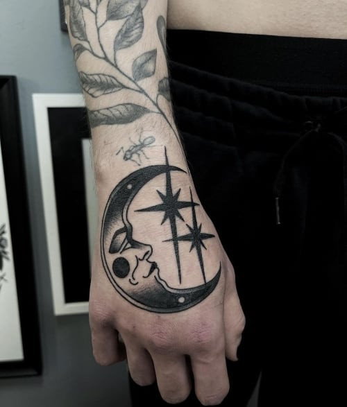 Crescent moon tattoo with stars on the back, a mystical men tattoo idea.