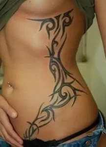 Intricate tribal pattern tattoo on the rib cage exuding strength