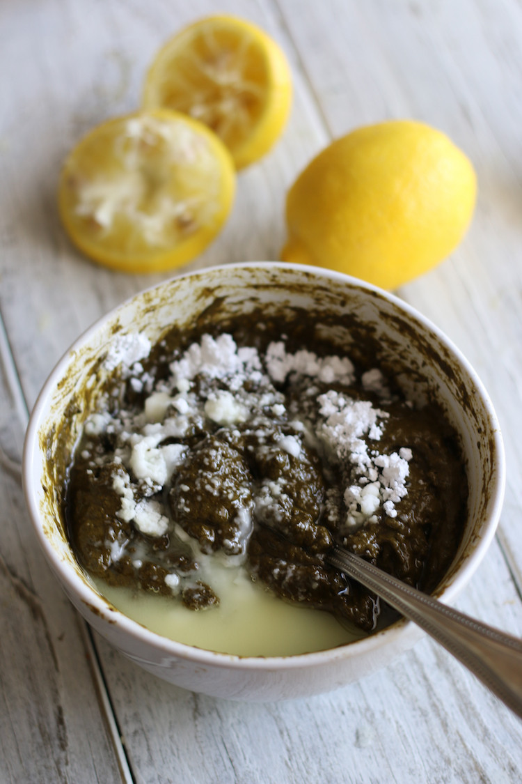 Mixing henna powder and lemon juice to create a smooth paste for temporary henna tattoos.