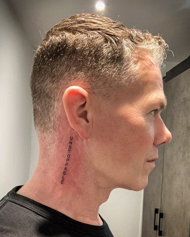 Word neck tattoo with bold lettering