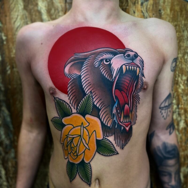 Neo traditional bear tattoo in a circular design, showcasing detailed fur texture.