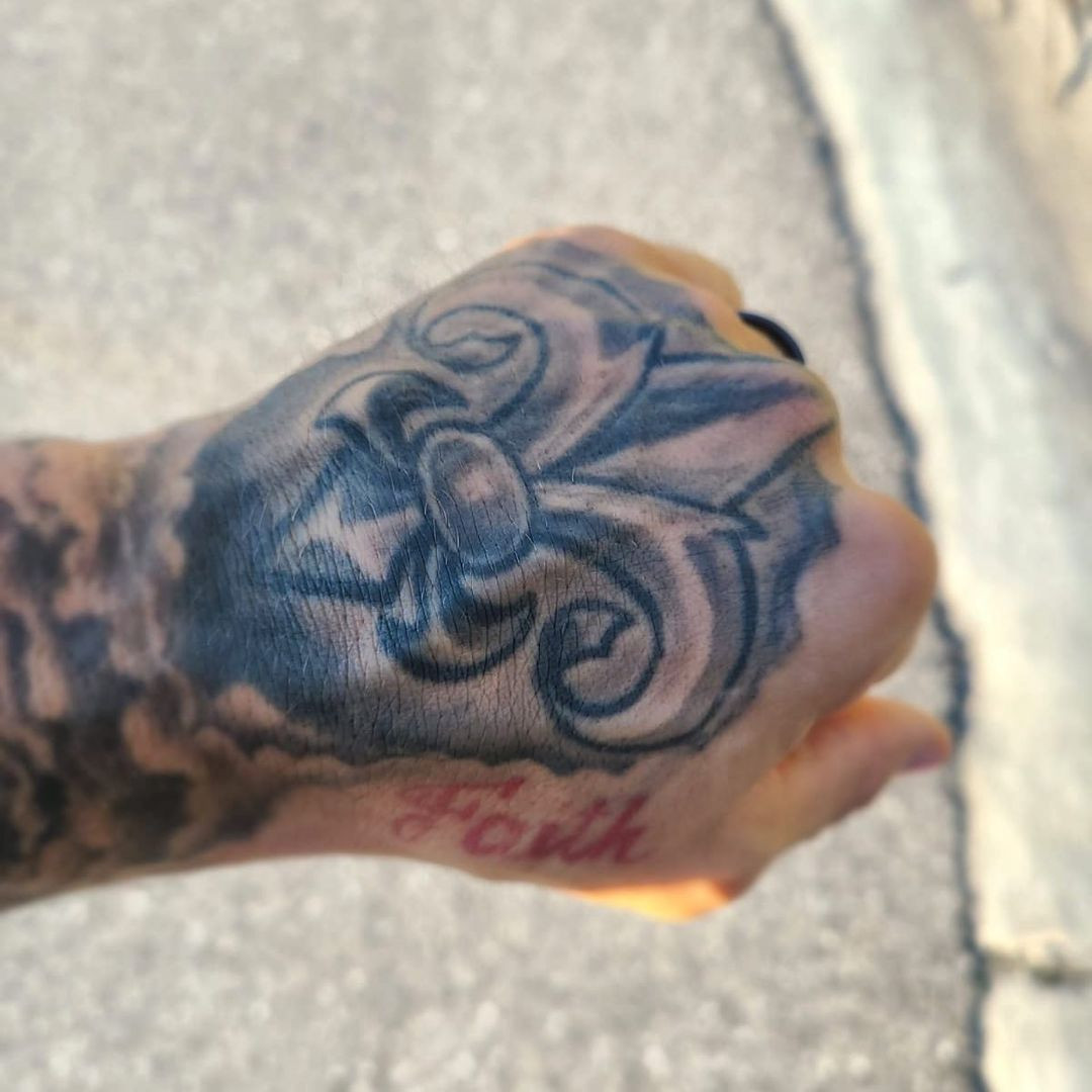 Detailed view of Dustin Poirier's left hand tattoo showcasing the fleur-de-lis and the word &quot;faith&quot;