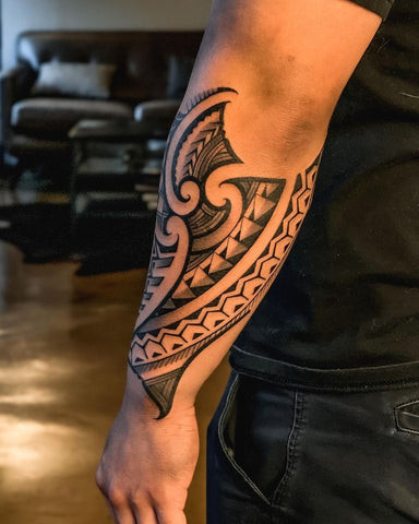 Geometric black ink outer forearm tattoo with sharp lines and bold patterns, appealing to men interested in modern and edgy tattoo styles.