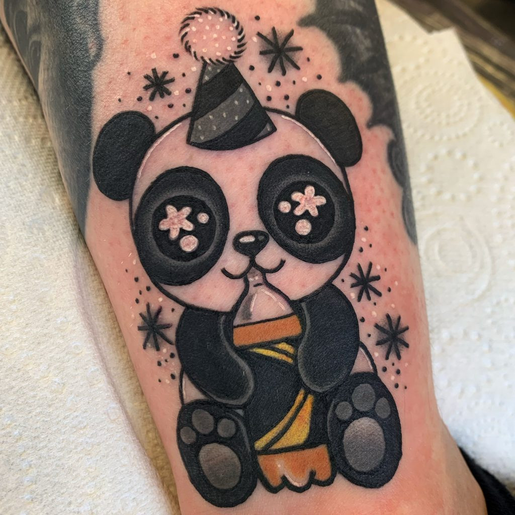 A charming cute panda tattoo with bright pink cheeks and a playful, friendly expression.