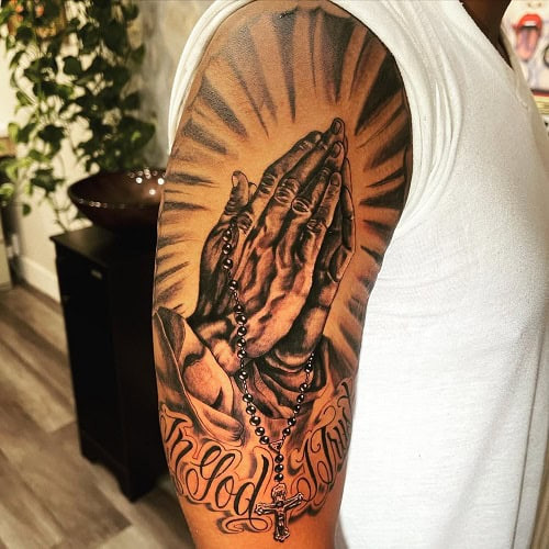 Black and grey praying hands tattoo on forearm