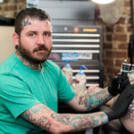 James Cooper, owner of Against All Odds Tattoo ATL, portrait in his studio