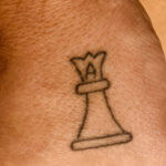 Minimalist queen chess piece tattoo on wrist