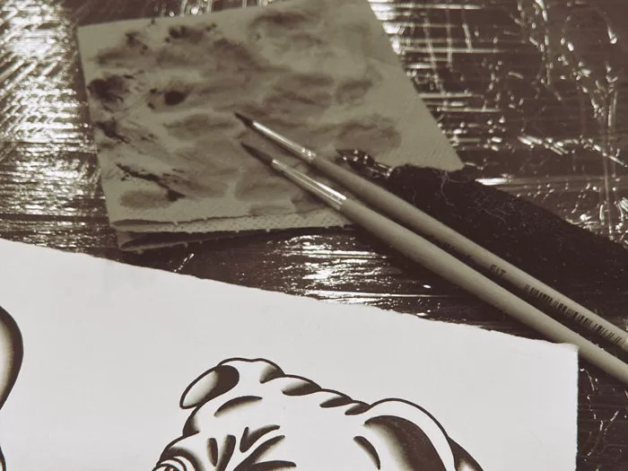 Vibrant colors being added to traditional tattoo flash art using liquid acrylic paints
