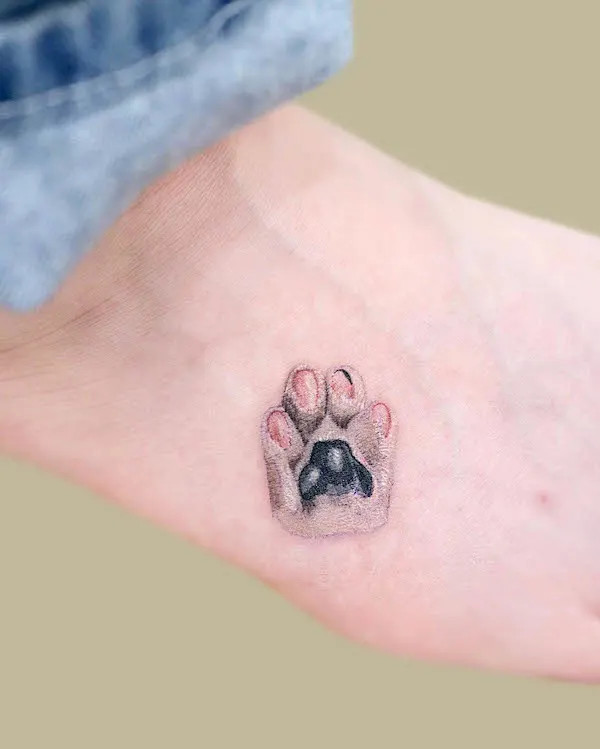 Realism paw tattoo, a detailed paw print representing love and connection with a beloved pet