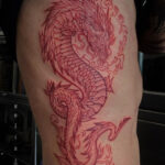 Vibrant red ink dragon tattoo on arm