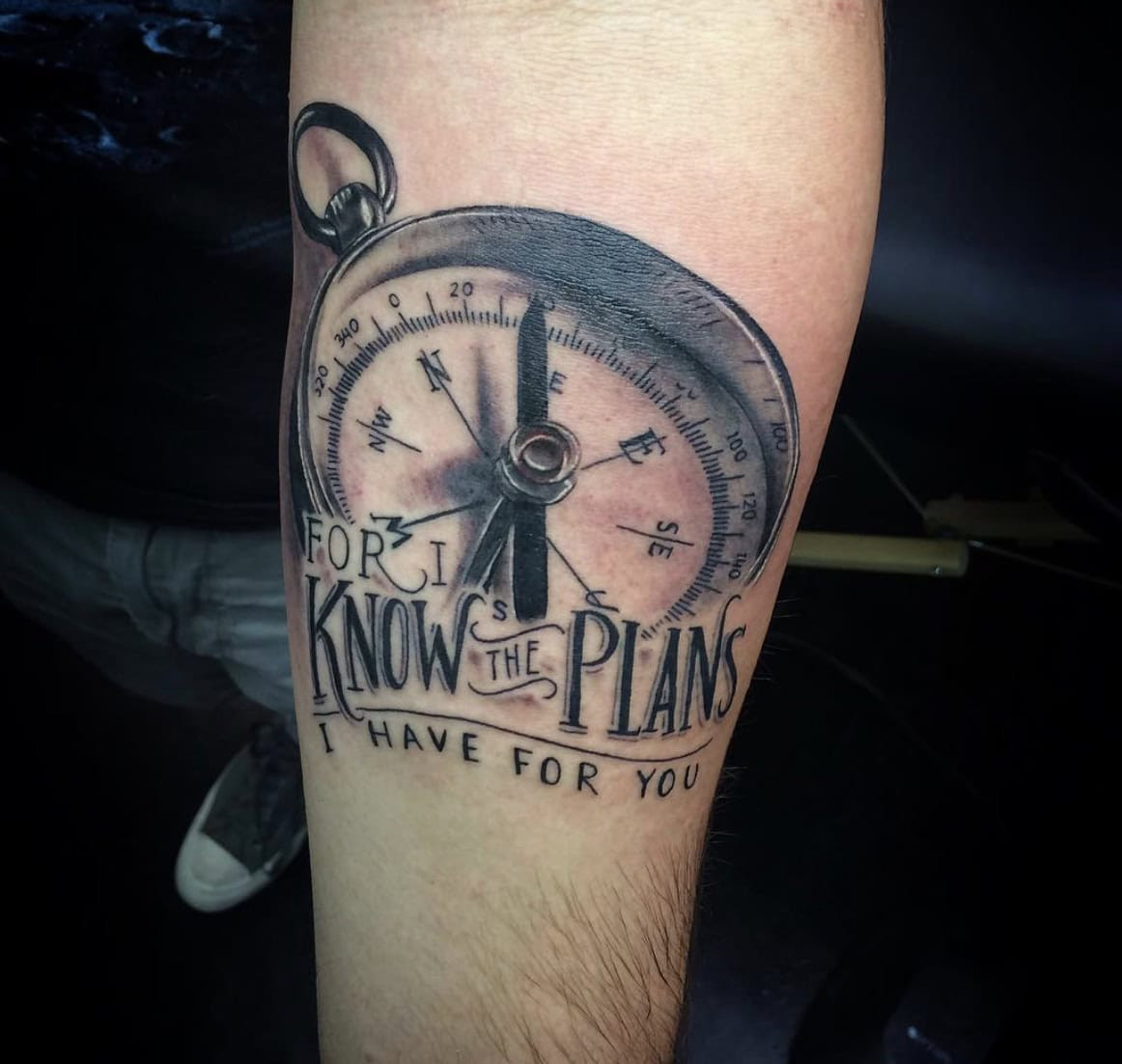 Religious compass tattoo on a man's forearm