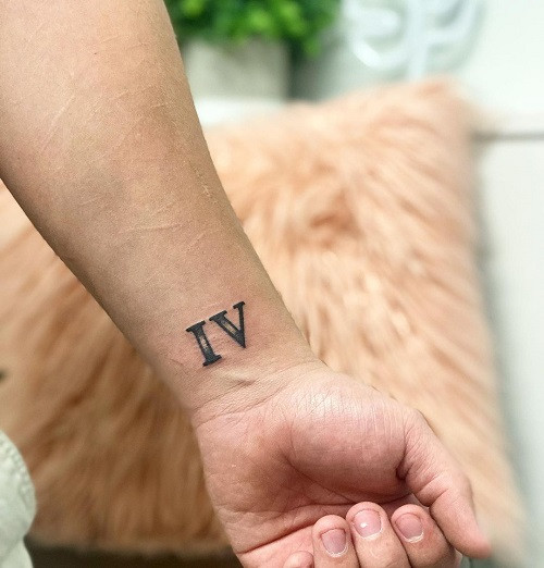 Elegant Roman Numeral 4 Tattoo on a man's arm