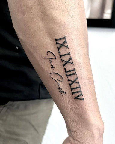 Elegant black ink roman numeral forearm tattoo with classic font, showcasing a timeless and meaningful design for men.