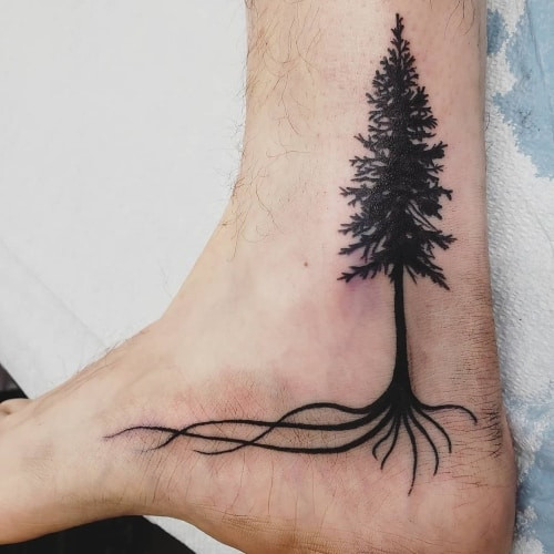 Minimalist tree roots tattoo on a man's chest