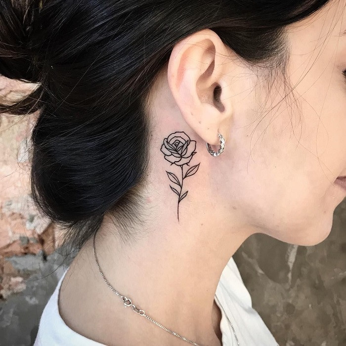 Skull and rose neck tattoo, contrasting life and death, beauty and mortality.