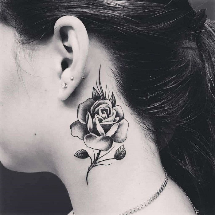 Butterfly and rose tattoo on the neck, combining symbols of transformation and beauty.