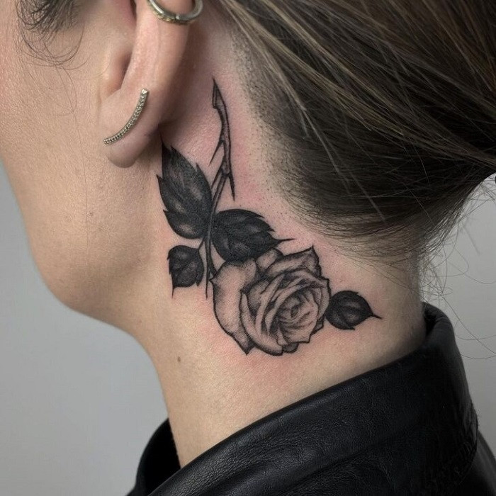 Small watercolor splash rose neck tattoo, abstract and vibrant, suggesting fleeting beauty.