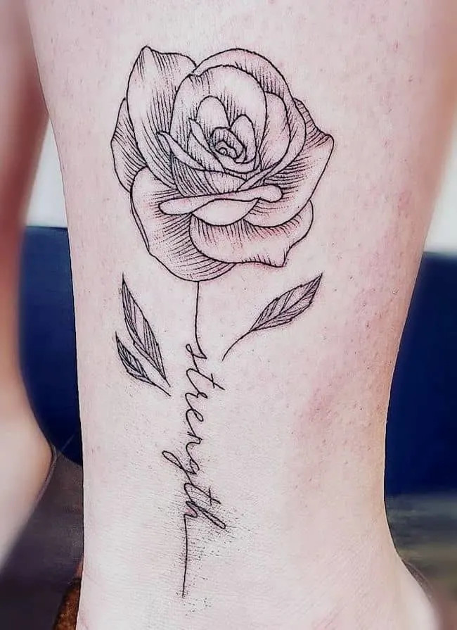 alt text: Elegant rose tattoo with the word &quot;Strength&quot; script underneath, symbolizing beauty, protection, and resilient feminine power