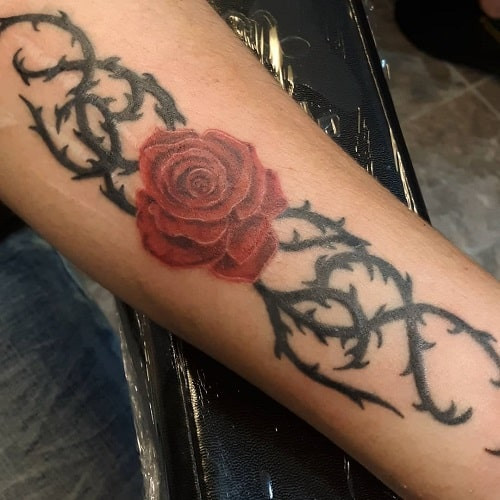 Complex rose with thorns tattoo symbolism