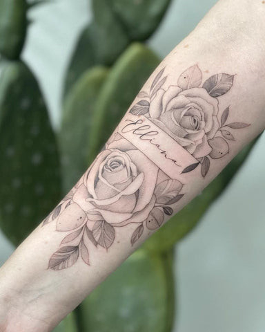 Simple yet elegant single black rose tattoo on a forearm, using fine lines and subtle shading for a minimalist aesthetic.