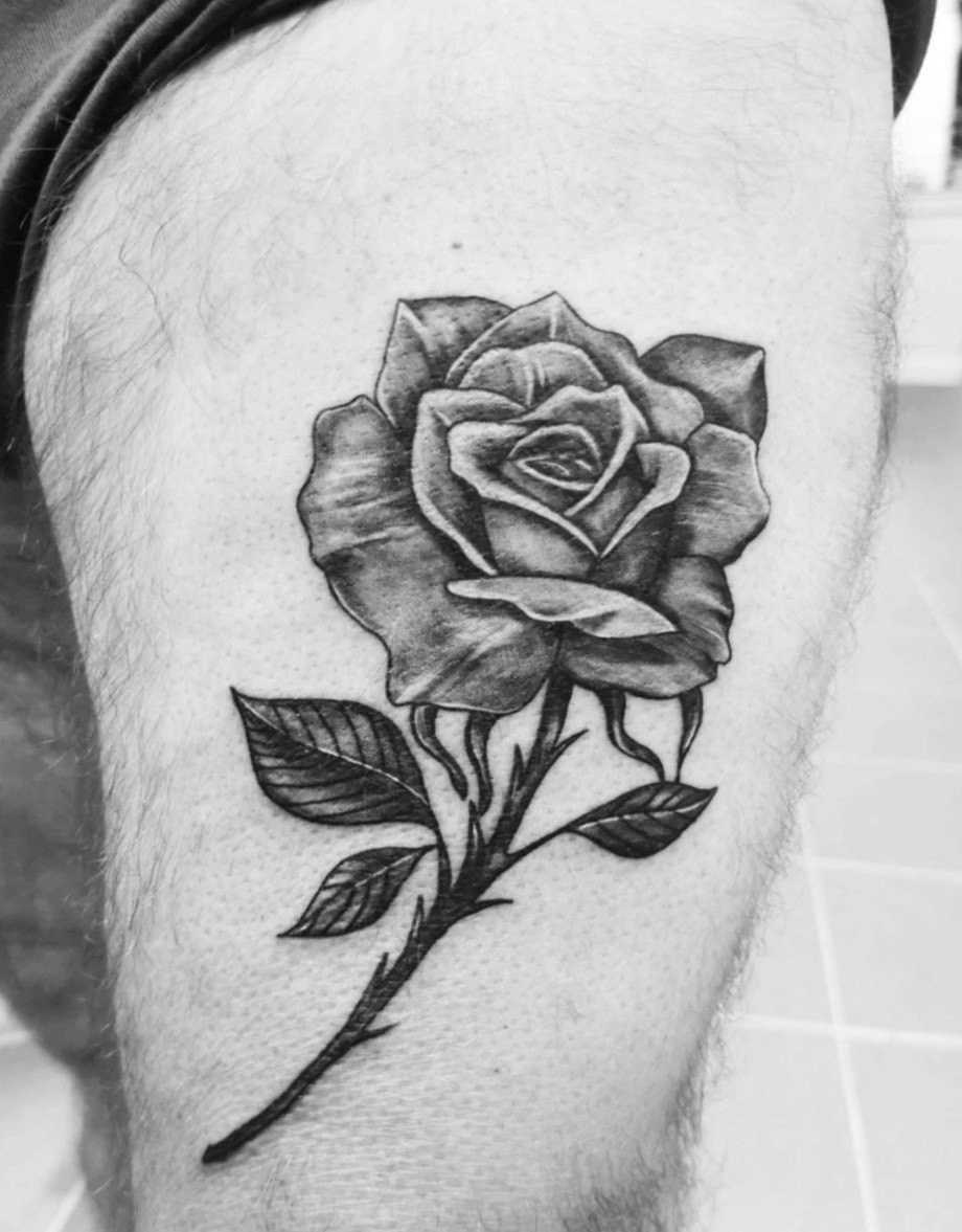 Spacious rose tattoo on thigh