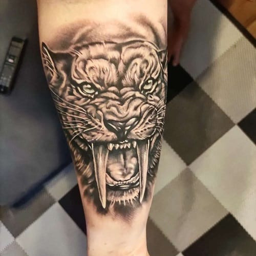 Unique sabre-toothed tiger tattoo with primal ferocity