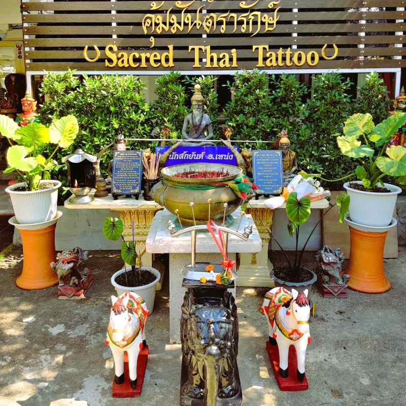 A traditional shrine in the courtyard of a Samnak in Thailand, where prayers and offerings are made before the Sak Yant ritual.