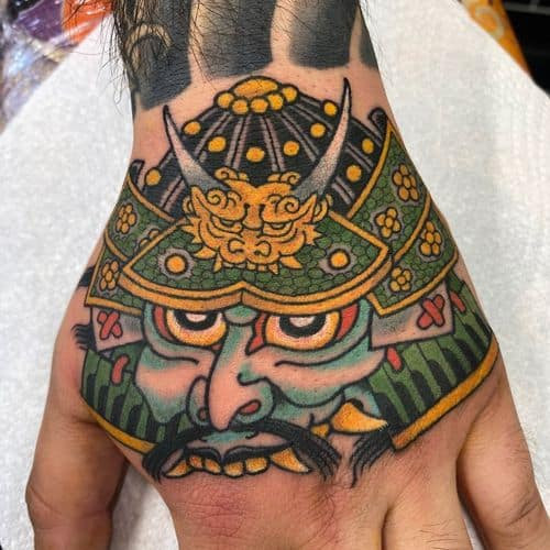 Stylized samurai mask tattoo on the arm, a modern take on warrior men tattoo ideas.