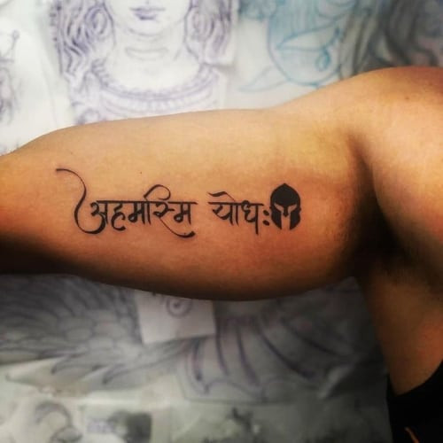 Sanskrit script tattoo on the arm, representing inner peace in men tattoo ideas.