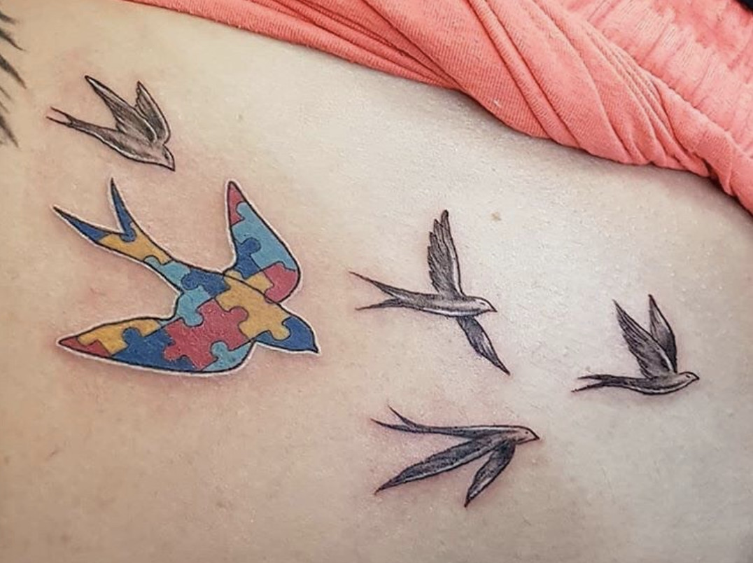 Colorful puzzle piece ribbon tattoo, a traditional symbol for autism awareness