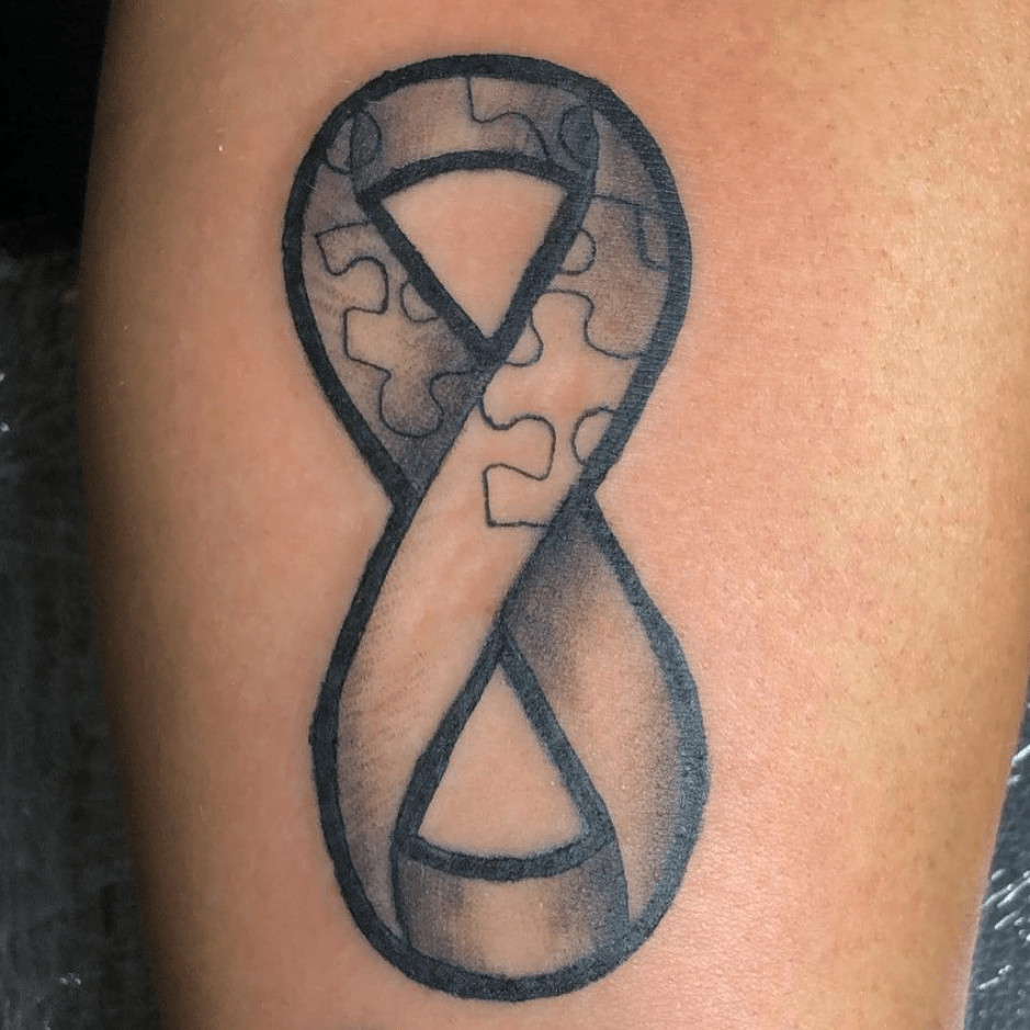 Elegant infinity symbol tattoo incorporating autism awareness colors, symbolizing endless potential.