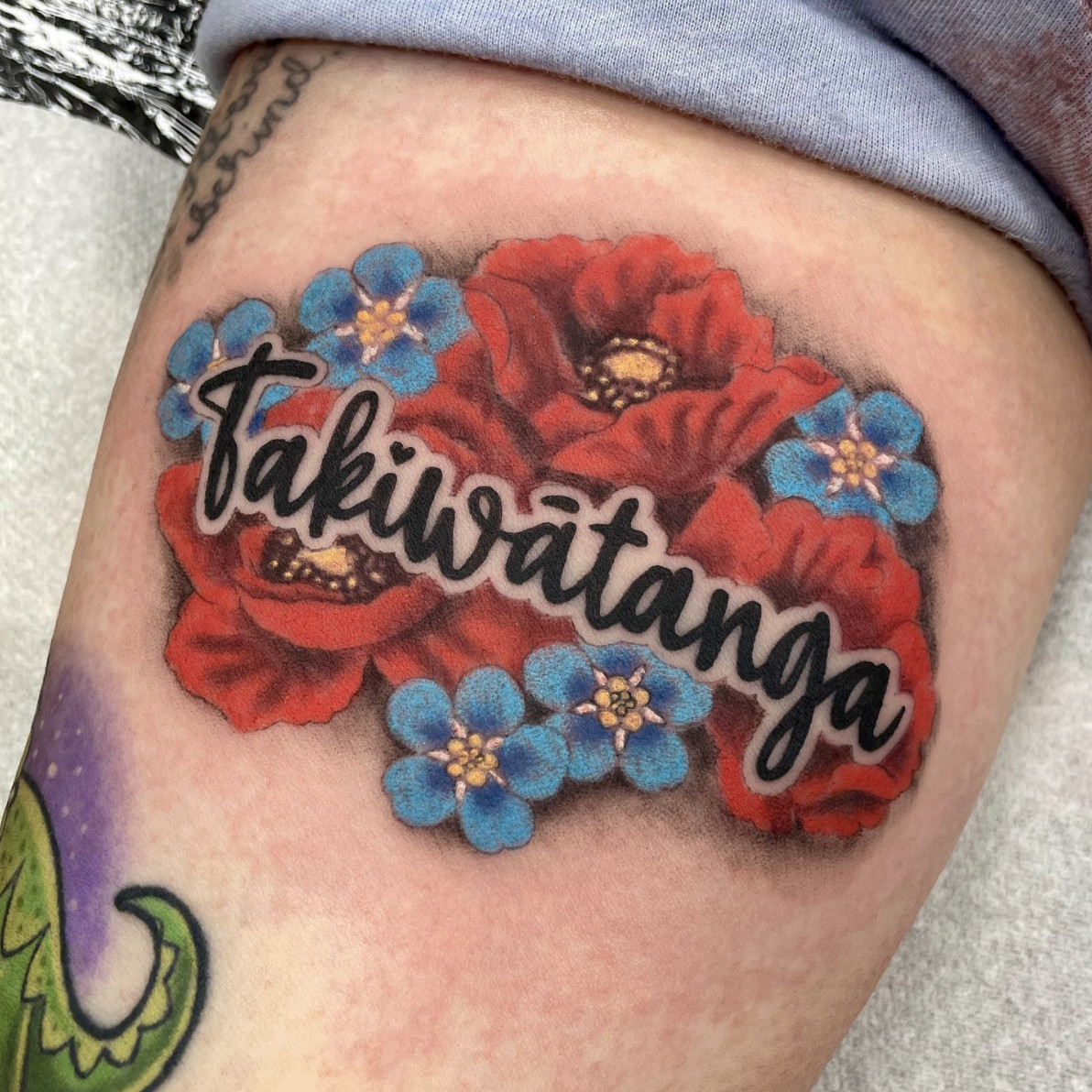 Takiwātanga text tattoo in elegant script on forearm