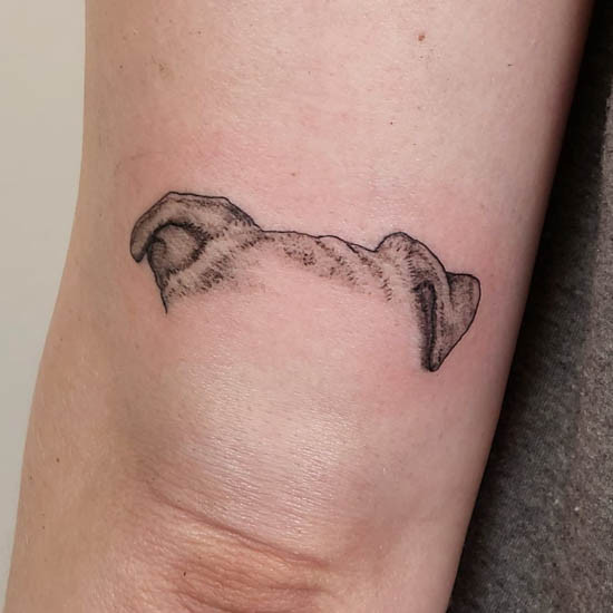 Shaded dog ears tattoo on forearm