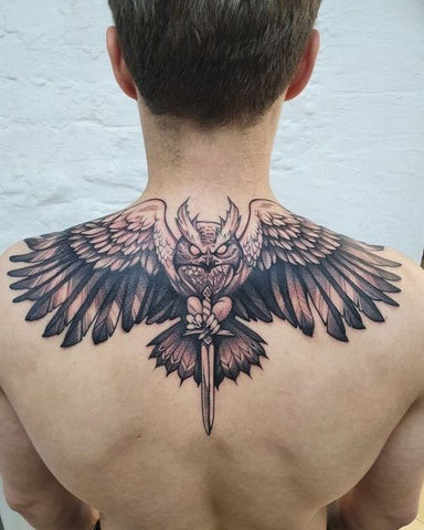 A mandala tattoo design centered on a man's shoulder blade