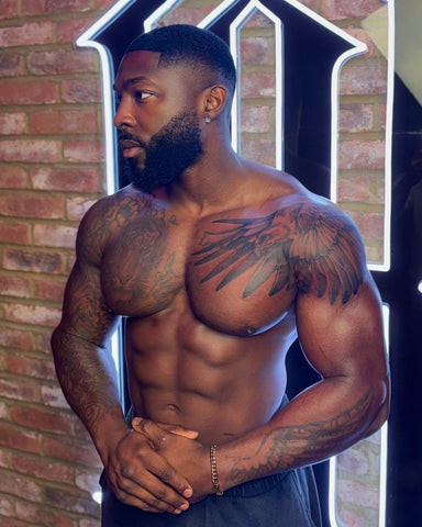 A bold black ink lion tattoo on a black man's shoulder