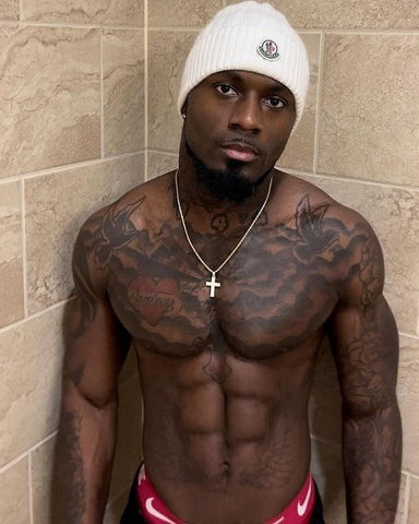 An intricate line work tattoo design on a black man's shoulder