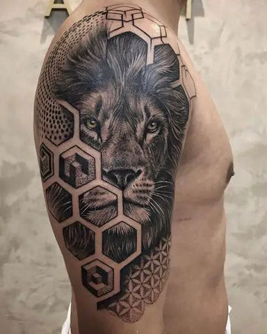 A realistic lion head tattoo on a man's shoulder