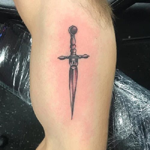 Simple dagger tattoo on hand, minimalist black ink design for men.