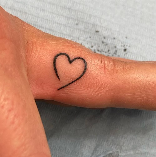 Simple heart outline tattoo on wrist, minimalist black ink design for men.