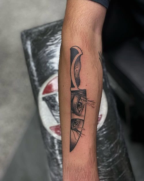 Simple knife outline tattoo on forearm, minimalist black ink design for men.