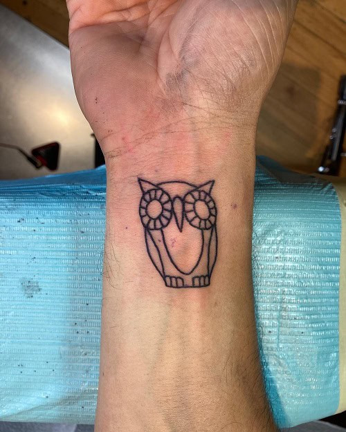 Simple owl outline tattoo on shoulder, minimalist black ink design for men.