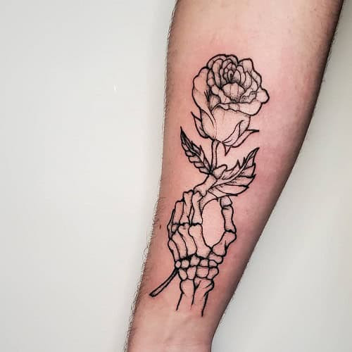 Simple skeleton hand tattoo on forearm, black linework minimalist style.