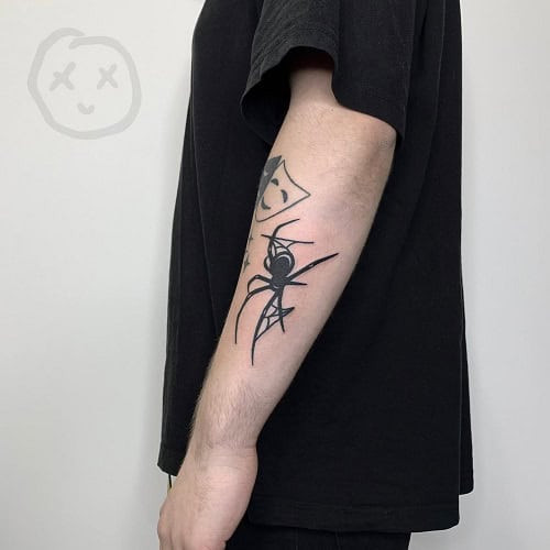 Simple spider outline tattoo on hand, minimalist black ink design for men.