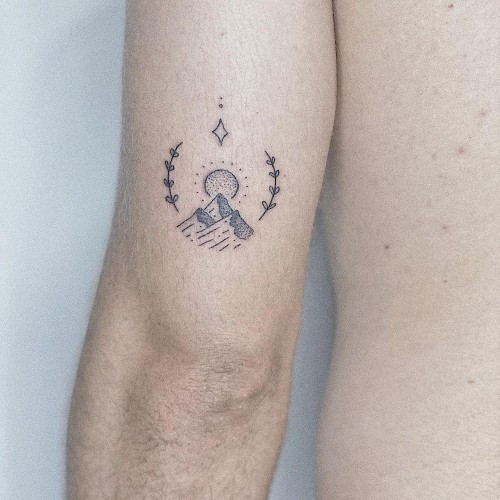 Two simple tattoos on men, one on the arm with a minimalist mountain range and another on the forearm with a single continuous line drawing.