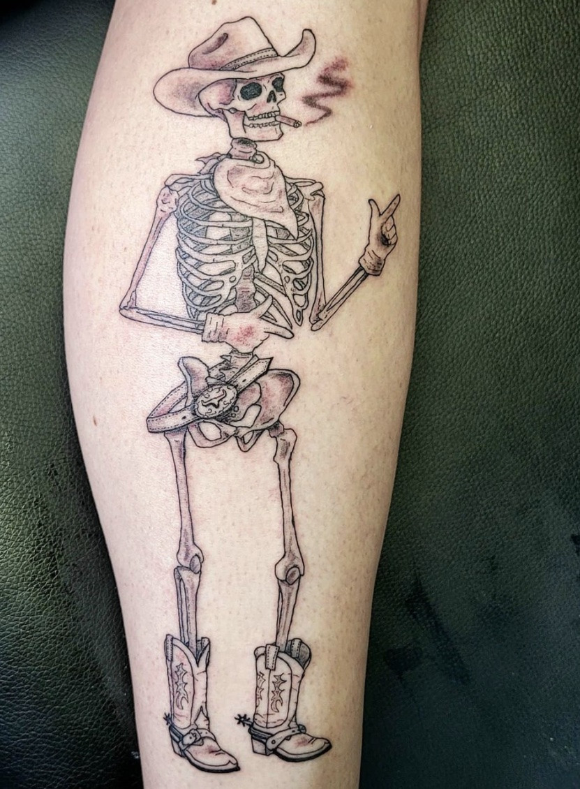 Black and grey skeleton cowboy tattoo riding a horse