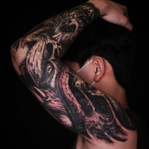 Full sleeve tattoo with biomechanical elements, a futuristic and detailed design for men.