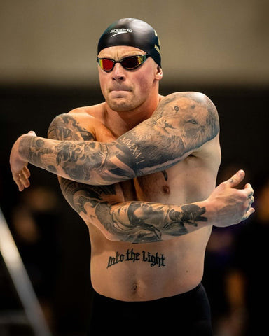 Adam Peaty showcasing his sleeve tattoos featuring a lion and roman numerals